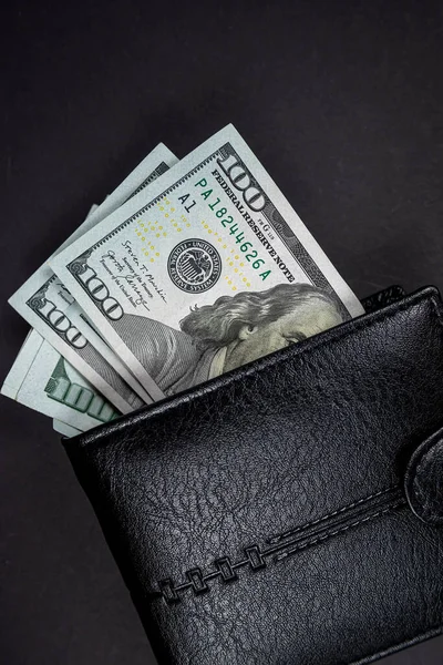 Open black wallet with cash US dollar bills isolated on plain background. View from above