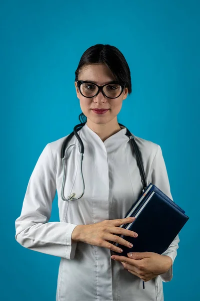Portret Młodej Wesołej Stażystki Okularach Noszącej Mundur Medyczny Trzymającej Książki — Zdjęcie stockowe