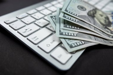 Çok güzel beyaz bir bilgisayar klavyesinin üzerinde büyük miktarda dolar var. Topallayarak izole edilmiş. İnternet geliri Hızlı para