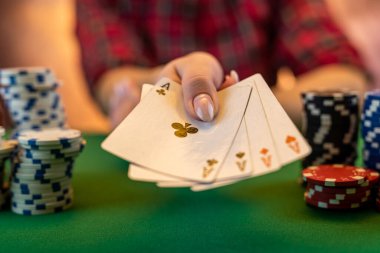 cropped portrait of a young girl playing a men's game at a poker table. poker game concept. big kush isolated