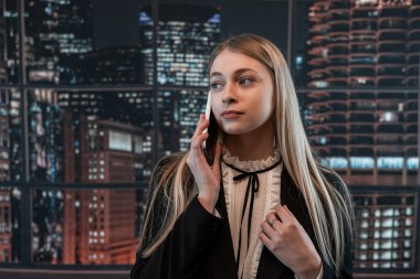 Güzel bayan işçi ofiste duruyor ve telefonda konuşuyor. Moda portresi