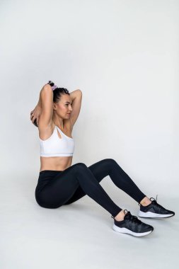 Güzel, genç, narin bir kadın spor salonunda spor topuyla jimnastik yapıyor. Ortasında da kum var. Sportif kız esniyor. Topu bir kadının ellerinde izole ettim.