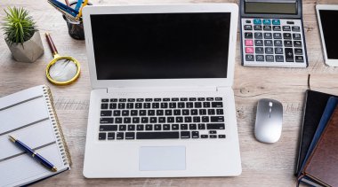 Laptop, boş not defteri, kalem hesap makinesi, ofis masasındaki hatırlatıcı çiçek. Üst Manzara. Mesafe ofisi
