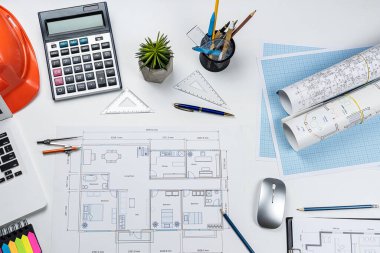 Ev planı, kalem hesap makinesi, kask, ofis masası. Mühendislik veya mimari kavramı