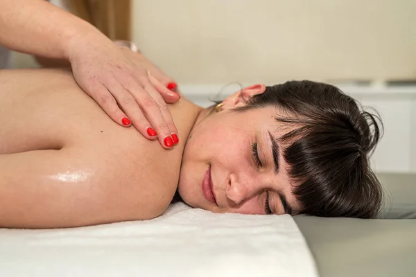 漂亮的高加索女性客人在温泉沙龙接受放松按摩 身体护理 生活方式 — 图库照片