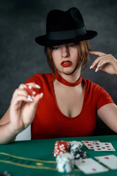美しい少女がポーカーテーブルに座ってるカードを手に 火かき棒のチャンスのゲーム 女性の手はポーカーカードを保持 — ストック写真