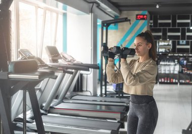Güzel, genç ve sportif bir kadın spor salonunda modern bir egzersiz makinesi üzerinde egzersiz yapıyor. En iyi spor salonu.