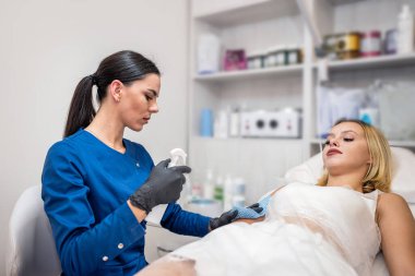 Güzeller güzeli kadın müşteriler için ağda yapma prosedürü uyguluyor. Epilasyon kozmetik güzellik kliniğinde