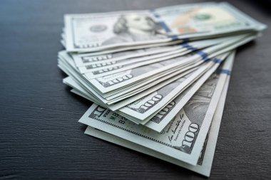 Siyah arka planda 100 yeni Amerikan doları. Gelir geliri. Kaydetme kavramı