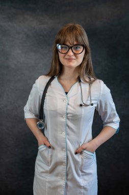 Kadın pratisyen hekimin ya da steteskoplu doktorun portresi karanlık, koronavirüs salgını konseptine izole edilmiş. Tıbbi kişisel