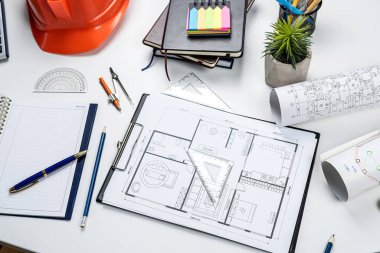 Ev planı, kalem hesap makinesi, kask, ofis masası. Mühendislik veya mimari kavramı