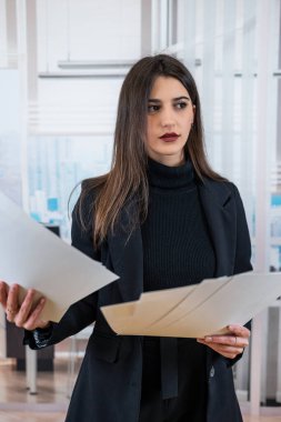 Ofiste poz veren, takım elbiseli, mutlu, kendine güvenen beyaz kadın yönetici. Başarılı bir iş kadını.