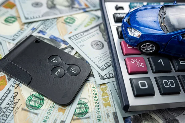 auto loan concept - small toy vechile, keys calculator and money all for buy or rent. Investment saving concept