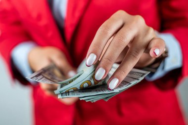 Ofiste para tutan neşeli genç bir kadının portresi sade bir arka planda izole edilmiş. İş kadını. Para için. nakit dolar