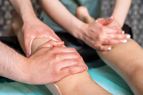 在一个现代美容院里用四只手按摩女性的脚 保健和自我护理的概念 抗纤维素按摩器 — 图库照片