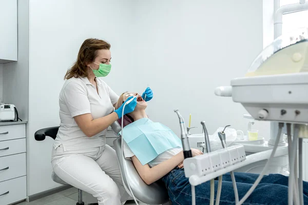 Dentista Feminina Trata Dentes Uma Jovem Paciente Deitada Clínica Odontologia — Fotografia de Stock