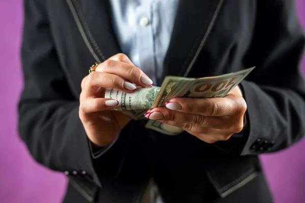 Photo of hands of a woman in classic clothes holding a fan of cash in dollars isolated over a white background. money in hand. business. profit. wealth