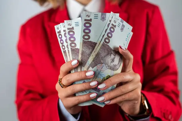 stock image Picture of excited young cheerful woman standing over pink background wearing strapless dress holding money. Looking camera pointing.