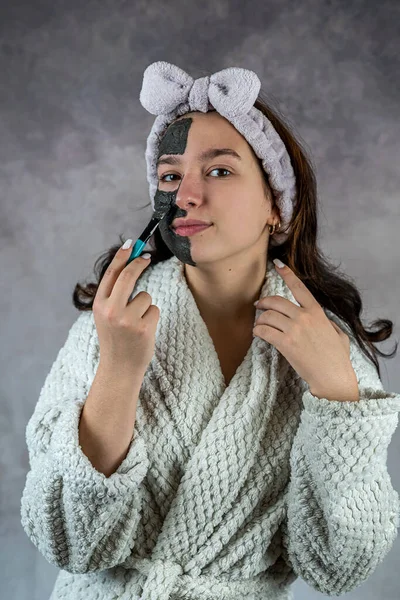 Mulher Bonita Aplicando Máscara Preta Seu Rosto Isolado Conceito Limpeza — Fotografia de Stock