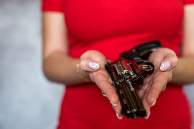 female spy agent with a gun in her hand on grey. crime concept