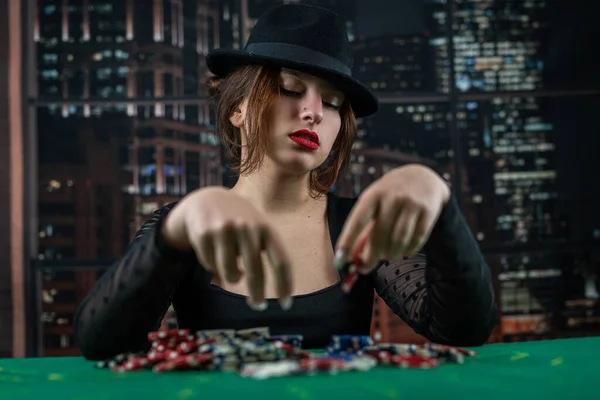 Atraktivní Dívka Černých Šatech Opírá Stůl Drží Pokerový Žeton Dívá — Stock fotografie