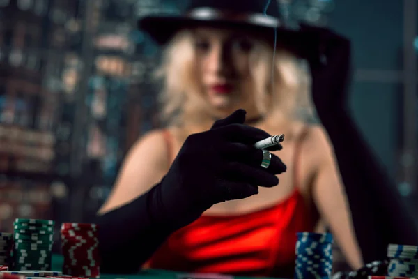 赤いドレスのきれいな女性はポーカーをプレーし タバコを吸う ギャンブルの概念 — ストック写真