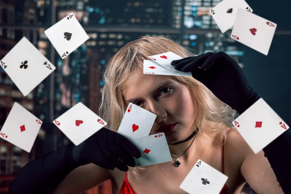 赤いドレスの女性はカジノゲームでフライプレイカードを投げる ギャンブルの概念 空を飛ぶカード秋 — ストック写真