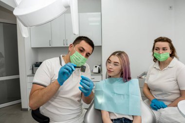 dentist explains the details of an x-ray to his female patient. concept of consultation in dentistry