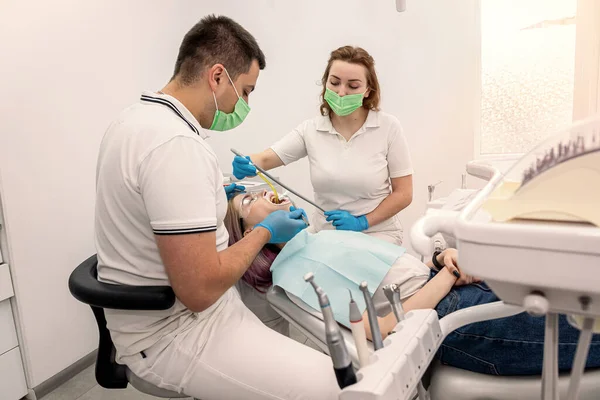 Erkek Dişçi Bayan Asistan Dişçi Kliniğinde Gülümseyen Genç Bir Kadını — Stok fotoğraf