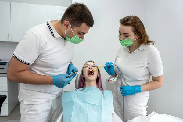 Young Woman Has Her Teeth Treated Male Dentist Female Assistant — Zdjęcie stockowe