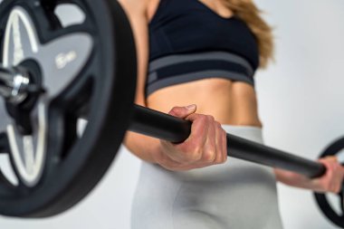 attractive strong adult woman with beautiful athletic body doing barbell exercises for abs. isolated on white studio wall. Fitness. bodybuilding Health care.