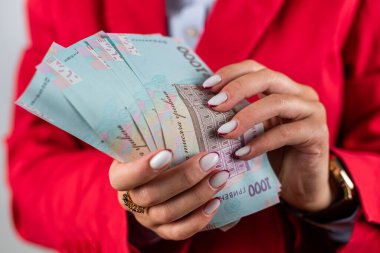 Kırılgan bir kadının genç elleri yelpaze tutuyor binlerce Hryvnia ile. Ukrayna parası. Zengin bir kadın Hryvnias 'ın ellerinde