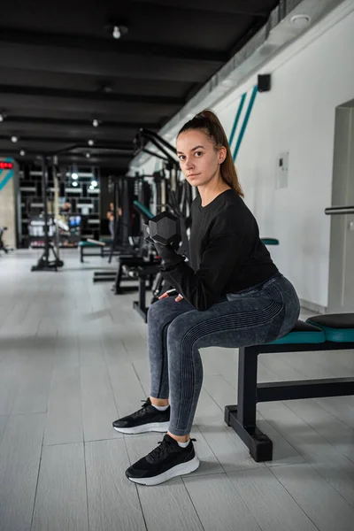 Güzel genç sporcu kadın spor salonunda kablo çapraz egzersizle egzersiz yapıyor. Kilo vermenin en iyi yolu