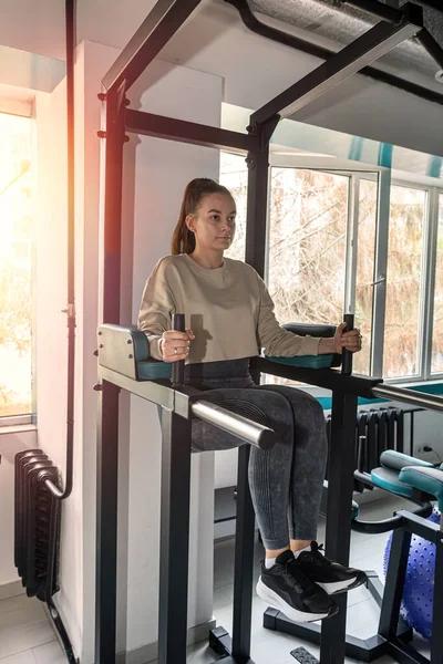 stock image Young women do sports outside the house and train in the gym. sportswoman stretching. meditates in the hall.