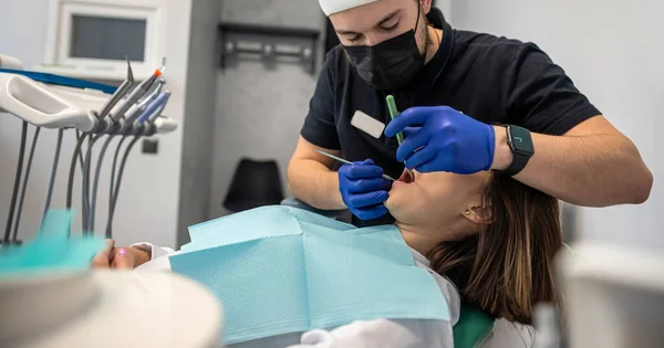 examination of a dentist treating a patient in a dental office. A woman has a scheduled dental examination at the dentist. dental problems