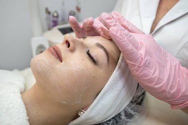 Beyaz kadın spa salonunda yüz masajı yaptırıyor. Vücut bakımı konsepti.