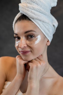 Havlu yapıştırılmış güzel bantları olan kadın siyah arka planda izole edilmiş. Güzellik bakımı için kozmetik.