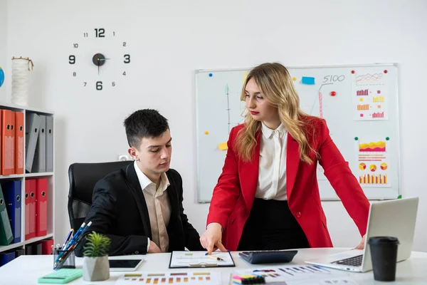 stock image Businesspeople wotk together analyzing financial reports using laptop and tablet computer at office desk. Two colleagues discussing data