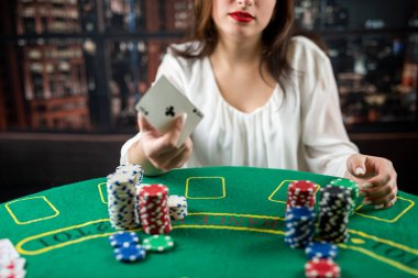 young luxurious woman came to play poker at a local casino. gambling concept. a woman wins in poker. cards. chips