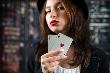 Casino woman with red lips holding ace with seductive lips and teeth. face close up Poker or other games concept.