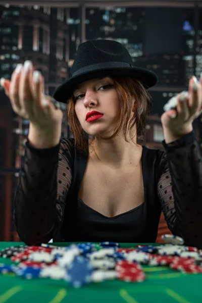 女性の手は丸いポーカーテーブルの山からポーカーチップを取ります ポーカーで危険な賭け カジノの女性は — ストック写真