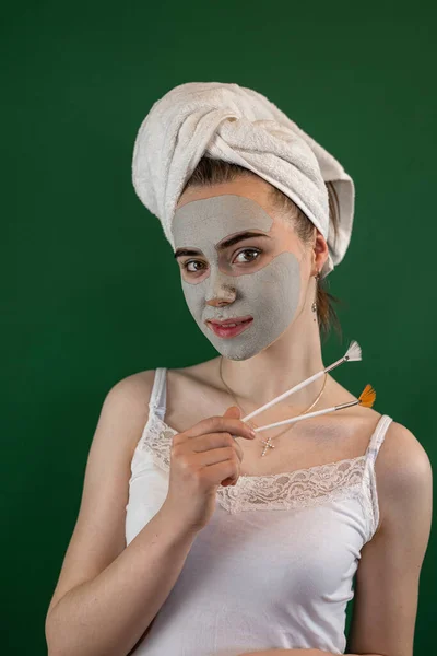 Młoda Kobieta Stosująca Zieloną Maskę Glinianą Odizolowana Zielono Zabiegi Kosmetyczne — Zdjęcie stockowe