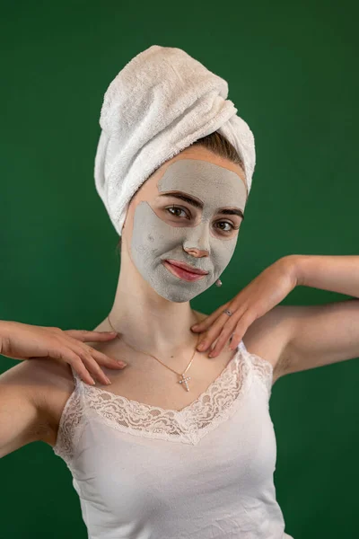 Jonge Vrouw Krijgen Groene Klei Gezichtsmasker Voor Huidverzorging Geïsoleerd Groen — Stockfoto