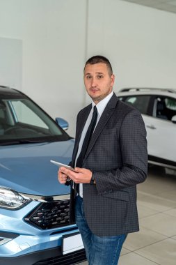  Takım elbiseli genç satıcı galeride müşteri bekliyor. Araba konsepti al. ulaşım
