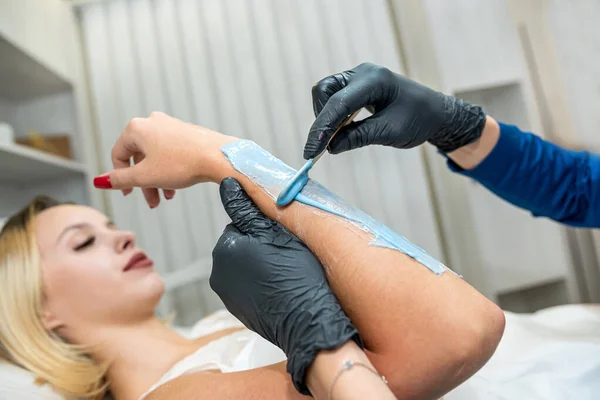 stock image beautician applies hair removal gel to the client's hand. sugaring procedure for healthcare lifestyle