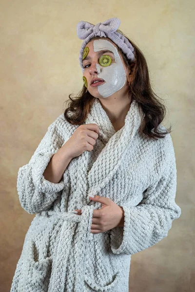 Vacker Kvinna Badrock Applicera Vit Mask Ansiktet Håller Skivor Kiwi — Stockfoto
