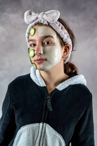 Cara Cliente Femenino Máscara Arcilla Blanca Mitigando Sosteniendo Rodajas Pepino —  Fotos de Stock