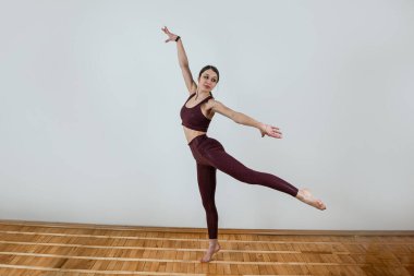 Kafkas formda bir kadın stüdyoda yoga minderinde egzersiz yapıyor. Sağlıklı yoga esnemesi