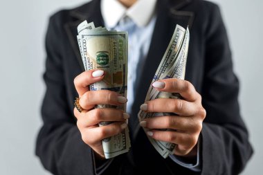 Photo of hands of a woman in classic clothes holding a fan of cash in dollars isolated over a white background. money in hand. business. profit. wealth