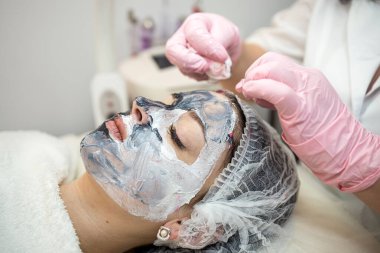 Kozmetik uzmanının elleri maskenin uygulandığı bir yüz masajı, konsept cilt bakımı ve tedavi